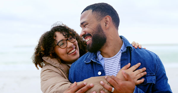 An African American couple hugging.